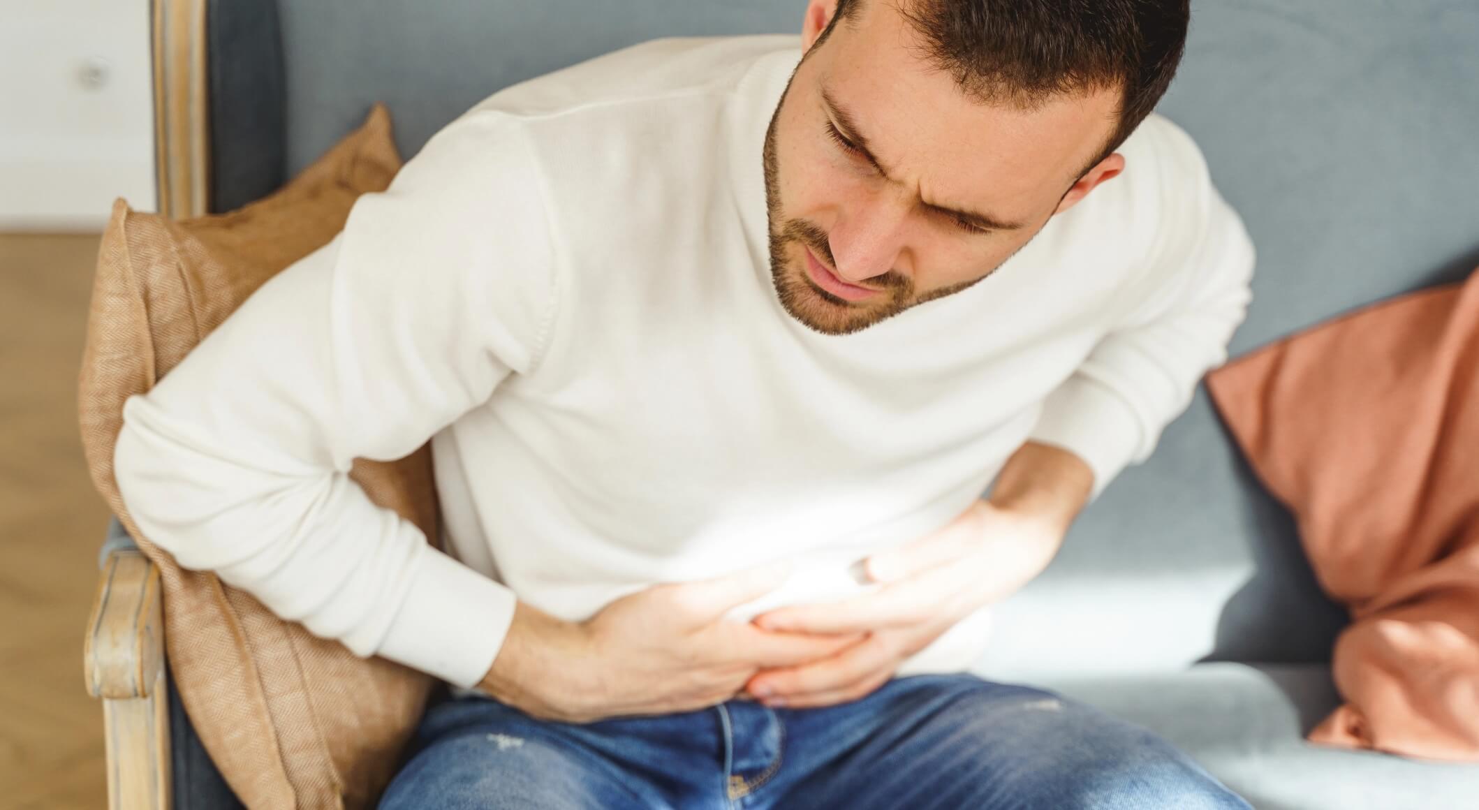 young-man-writhing-in-a-stomach-pain-2023-11-27-04-57-06-utc@2x (1)